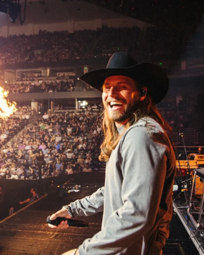 Kolby Cooper performing on stage at a country music event.